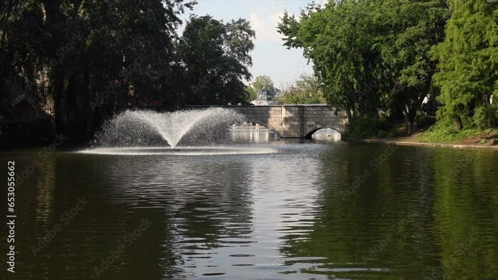 Water fountain in lake with bridge in background. Water fountain in lake with bridge in background.
