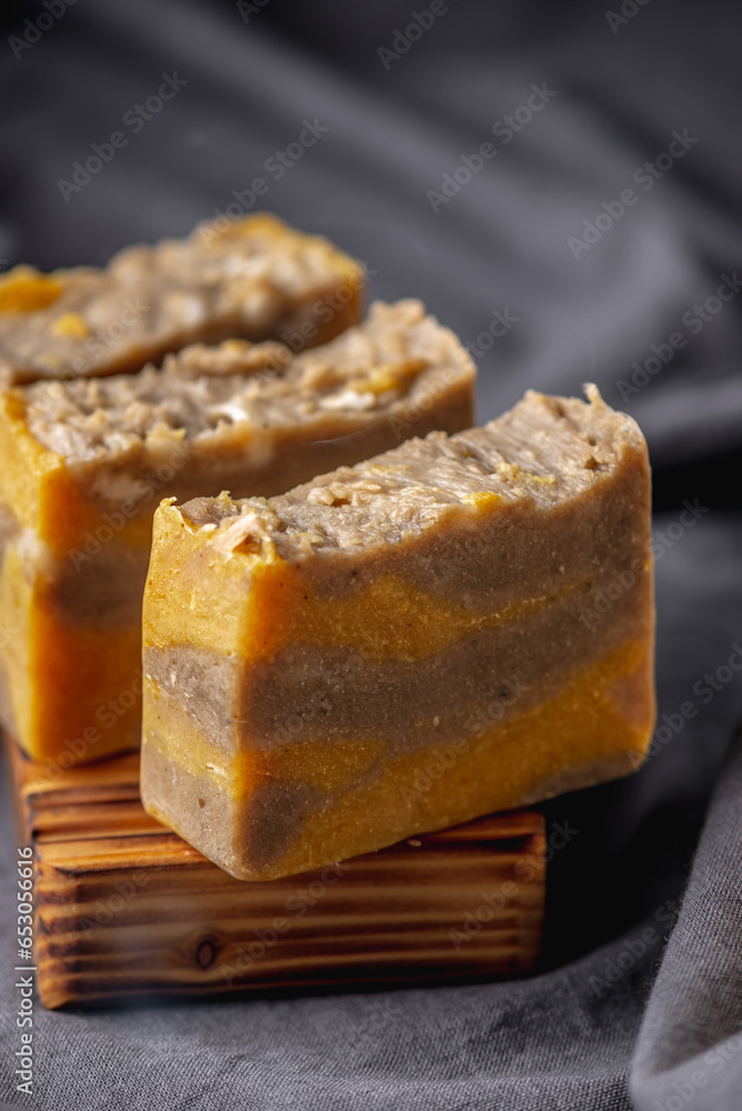 Pieces of natural handmade soap on a wooden soap dish and the dark background Pieces of natural handmade soap on a wooden soap dish and the dark background