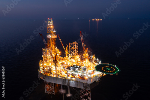 Aerial view of jack up drilling rig in the middle of the ocean while rig move at night time