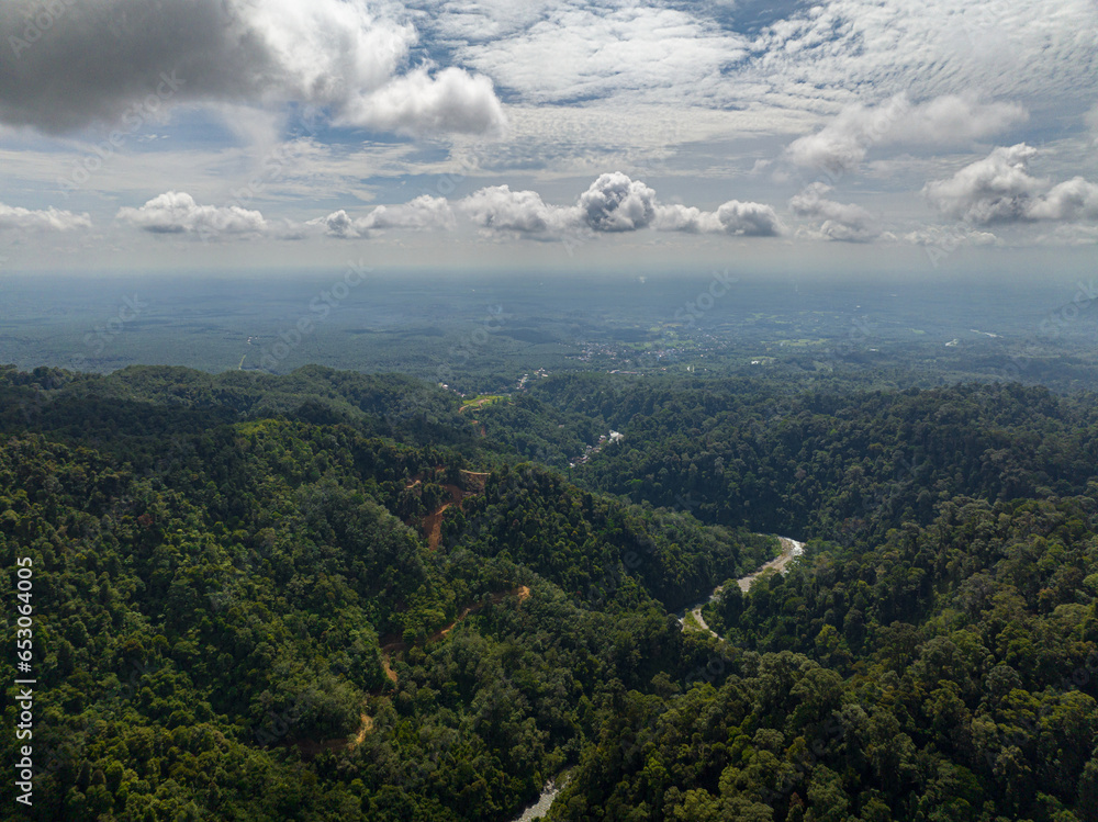 Aerial drone of mountains covered rainforest, trees and blue sky with clouds. Sumatra, Indonesia.