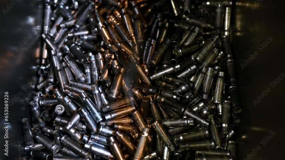 Metal bullet casings fall down into large container at plant Stock ビデオ