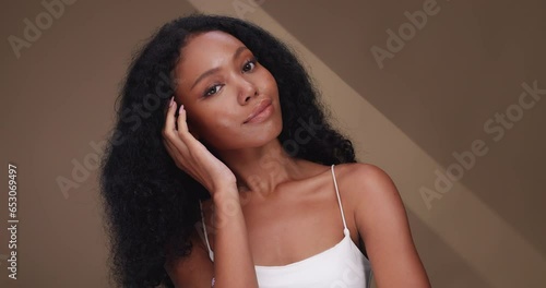 Portrait of a black girl with curly hair, soft makeup and perfect skin. Beautiful face of young black woman with natural skin. photo