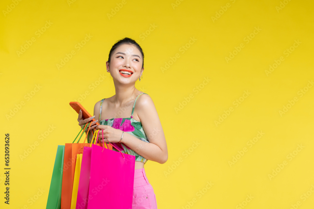 Fototapeta premium Women carrying a lot of colorful shopping bags and mobile phone,Selective focus