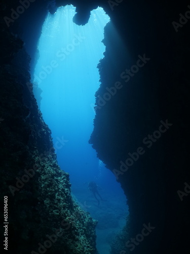 underwater in cave beautiful light scenery in ocean scuba divers to see in cave backgrounds © underocean