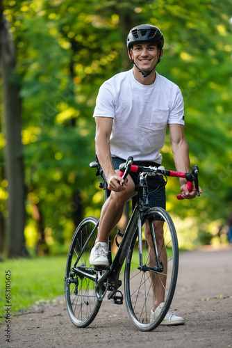 Fototapeta Naklejka Na Ścianę i Meble -  Well-built young cyclist on a bike looking confident