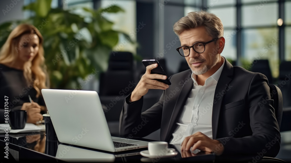 Businessman working with laptop computer and phone in modern office. Businessman working with laptop computer and phone in modern office.