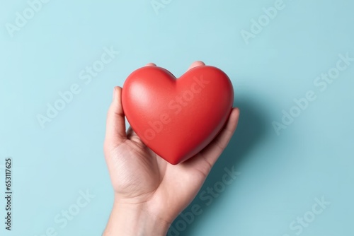 Man hand holding a red heart shape isolated on plain background