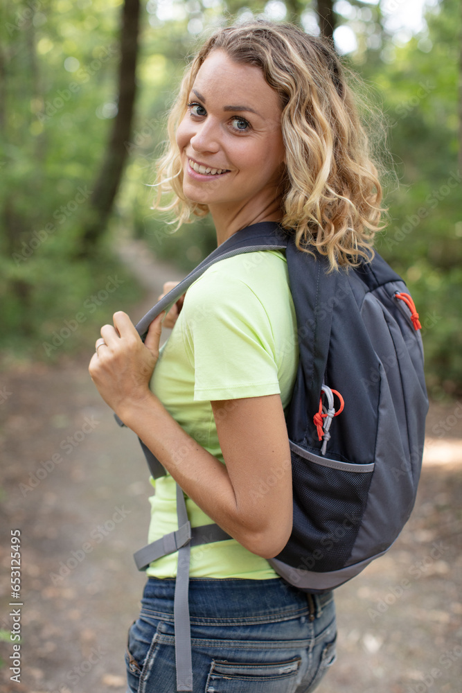 woman alone in the woods wearing a backpack woman alone in the woods wearing a backpack