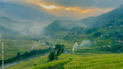 Mu Can Chai, harvesting rice terrace fields landscape with fire smoke on horizon near Sapa, Northern Vietnam