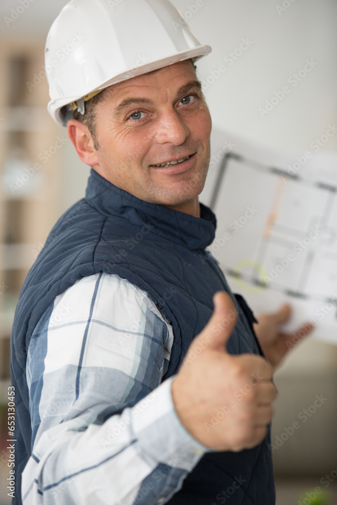 architect holding floorplan holding thumbs up architect holding floorplan holding thumbs up
