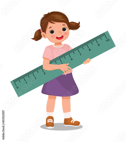 Cute little girl student holding big ruler