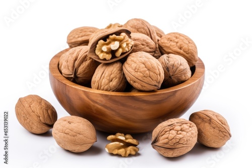 Walnuts in wooden bowl on a white background.