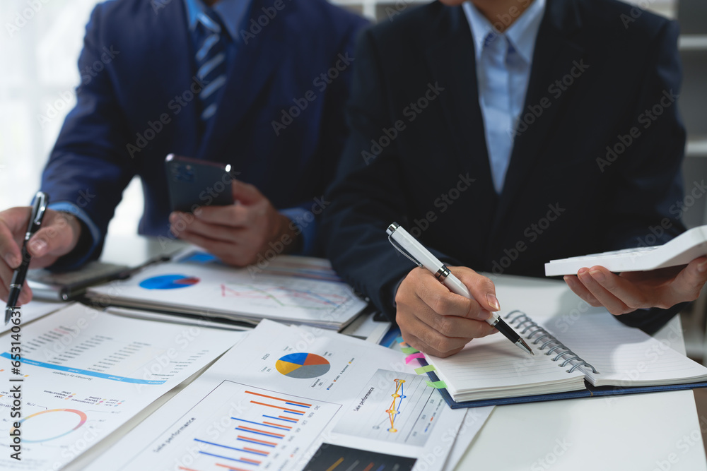 Fototapeta premium Business team Negotiation, Analysis, Discussion, Asian woman economist and marketer pointing to a financial data sheet to plan investments to prevent risks and losses for the company