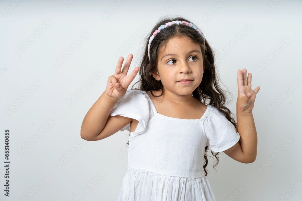beautiful kid girl wearing dress showing and pointing up with fingers number eight while smiling confident and happy. beautiful kid girl wearing dress showing and pointing up with fingers number eight while smiling confident and happy.