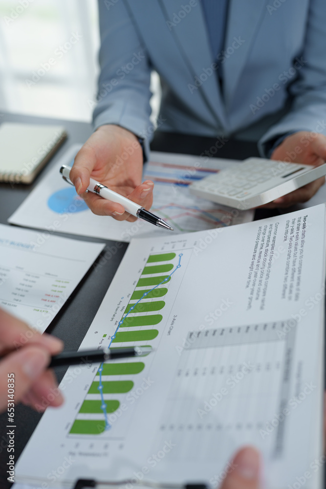 team work process Business team use calculator to calculate figures, business statistics, profit, cost analysis, growth rate graph document. data charts on the desk team work process Business team use calculator to calculate figures, business statistics, profit, cost analysis, growth rate graph document. data charts on the desk
