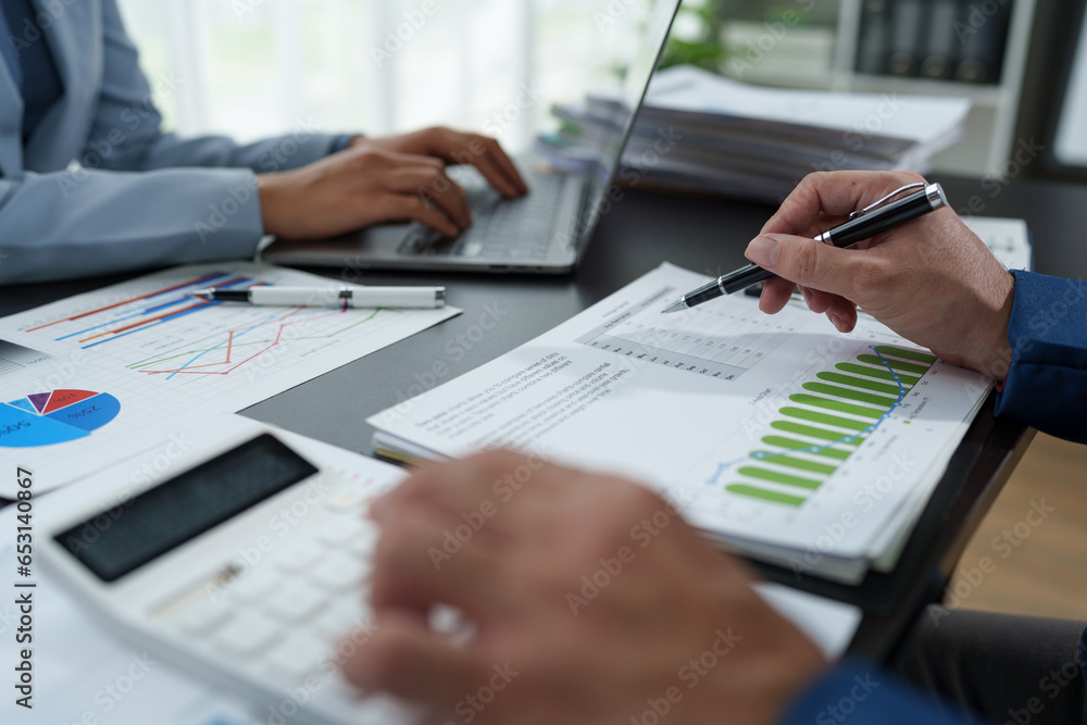 team work process Business team use calculator to calculate figures, business statistics, profit, cost analysis, growth rate graph document. data charts on the desk team work process Business team use calculator to calculate figures, business statistics, profit, cost analysis, growth rate graph document. data charts on the desk