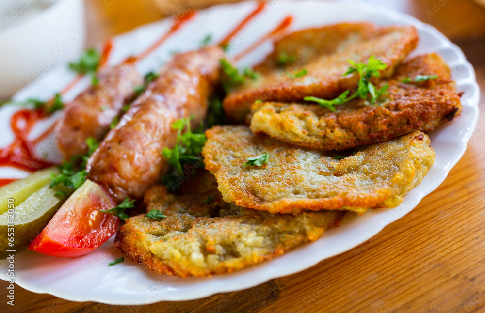 Belarusian pancakes with sausages in a restaurant Belarusian pancakes with sausages in a restaurant