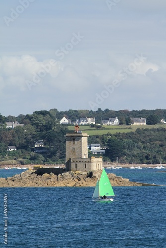 voilier aux voiles vertes navigant devant l'île noire en baie de Morlaix en Bretagne