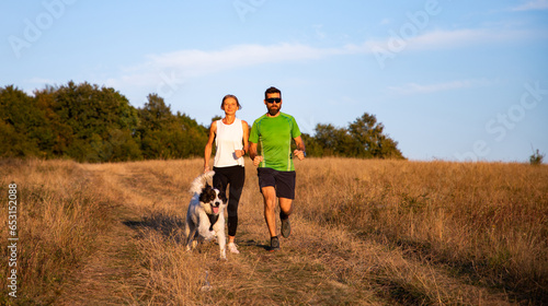 fit couple running with dog