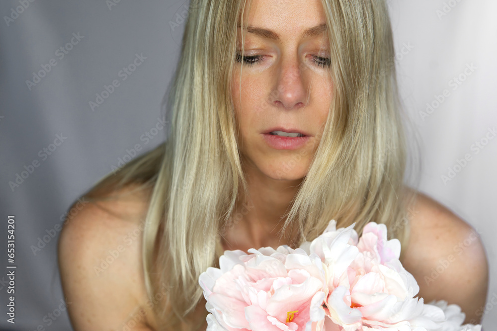 Beautiful blond woman face with rose flowers on breast Beautiful blond woman face with rose flowers on breast