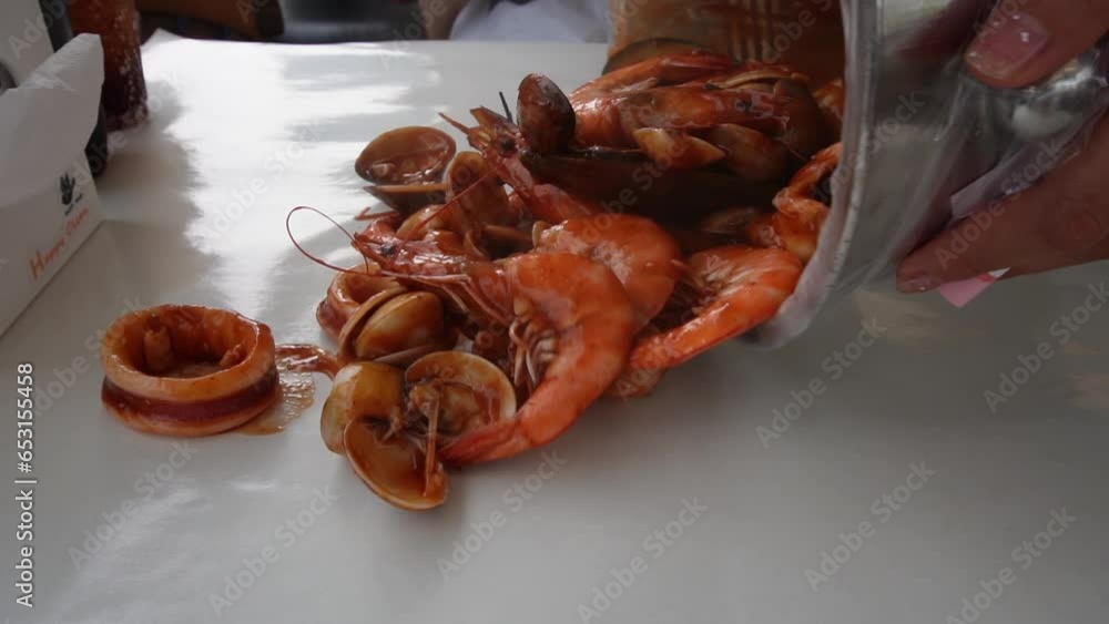 Pouring seafood bucket on to the table, where you eat with your bear