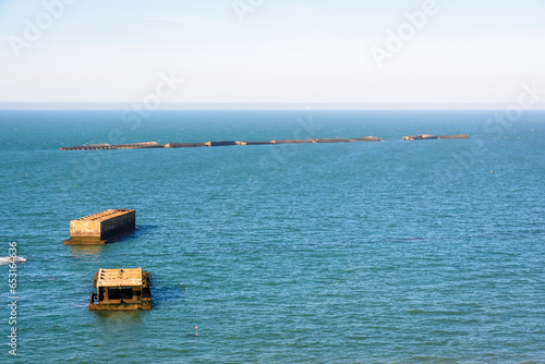 Remains of Phoenix caissons used to build the artificial Mulberry harbour on Gold Beach after the Normandy landings in World War II, seen from Cap Manvieux in Tracy-sur-Mer, France. photo