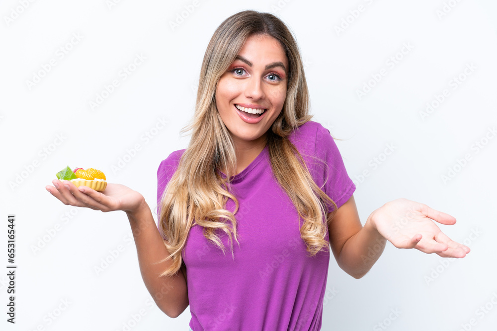 Young pretty Uruguayan woman holding a tartlet isolated on white background with shocked facial expression Young pretty Uruguayan woman holding a tartlet isolated on white background with shocked facial expression