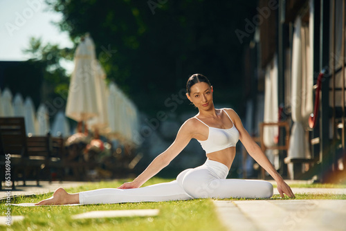 Brown hair. Young woman in yoga clothes is outdoors photo