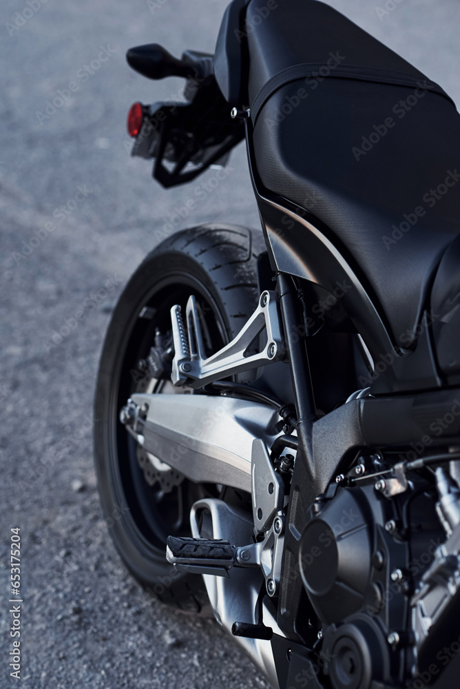 Black colored vehicle. Close up view of modern motorcycle that is parked outdoors Black colored vehicle. Close up view of modern motorcycle that is parked outdoors