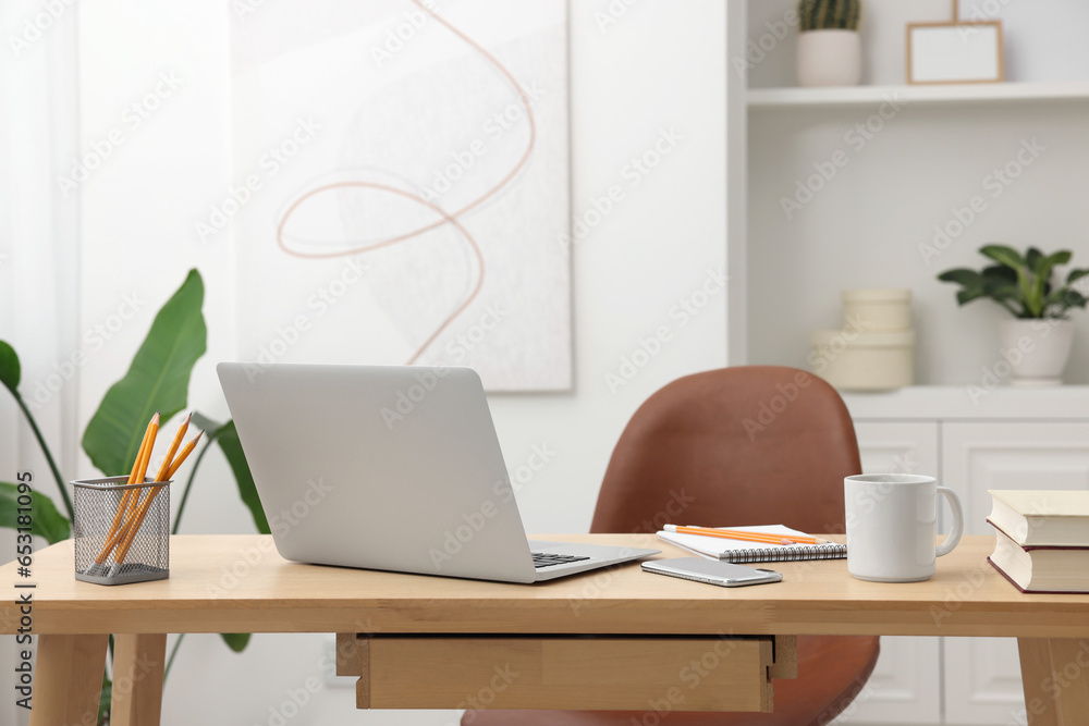 Fototapeta premium Home office. Stylish workplace with laptop and stationery on wooden desk indoors