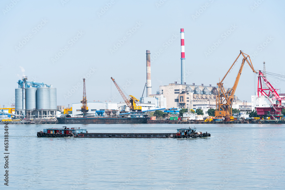 View of industrial plant and smoke stacks ,Container ship on river harbor, Shanghai, China