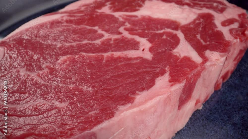 entrecôte ribeye steak close up, rotation, 4k macro view of red meat with fat on blue plate, beef entrecôte ribeye steak close up, rotation, 4k macro view of red meat with fat on blue plate, beef