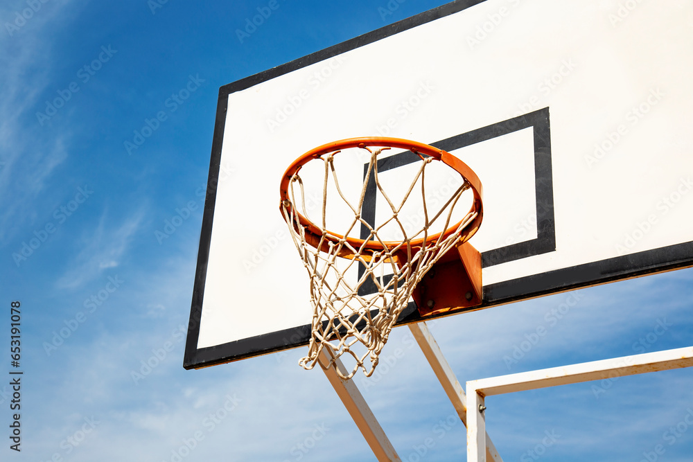 basketball hoop on white nackboard against blue sky