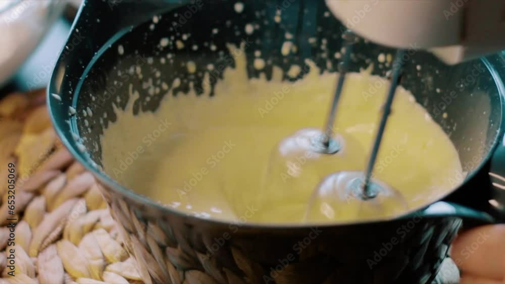 Preparing cake dough, cream is mixed with a blender Preparing cake dough, cream is mixed with a blender