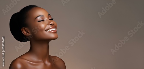 A joyful beautiful African-American woman with delicate flawless skin  enjoying the result of cosmetic procedures.