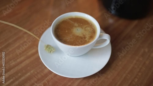 A cup of coffee is on the table. Close-up.