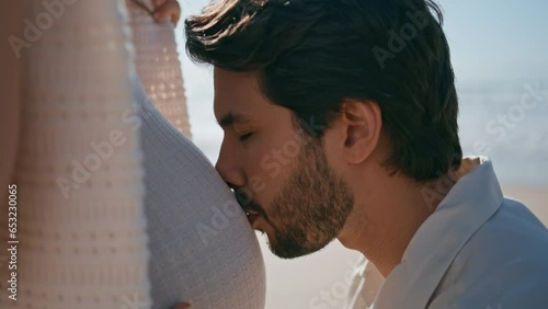 Man kissing pregnant belly wife standing seashore close up. Future father love 