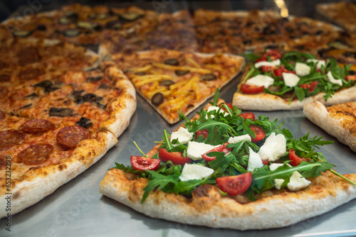 Close-up of a slice of pizza in a cafe. Sale of ready-made pizza in a pizzeria. Italian pizza