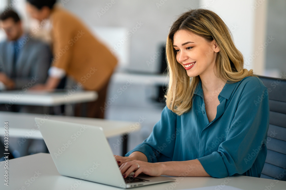 Young happy successful business woman working with laptop in corporate office Young happy successful business woman working with laptop in corporate office