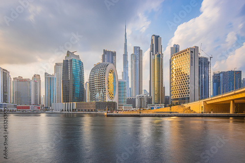 Sunset in Dubai. Skyscrapers and Burj Khalifa in the evening. Skyline with cloudy sky and waterfront in Dubai port. Houses with glass front and concrete facades architecture photo
