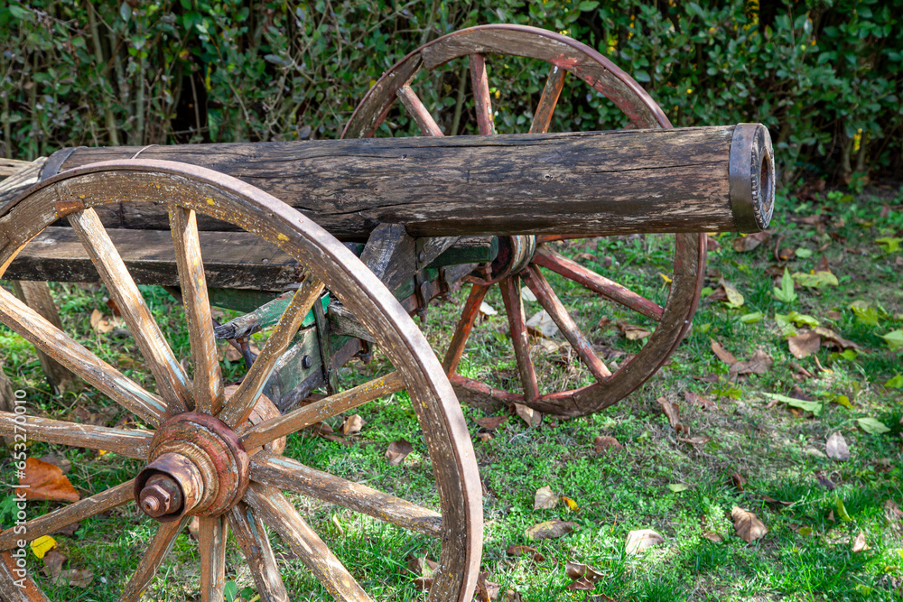 Old antique cannon with wooden wheels on grass. Old antique cannon with wooden wheels on grass.
