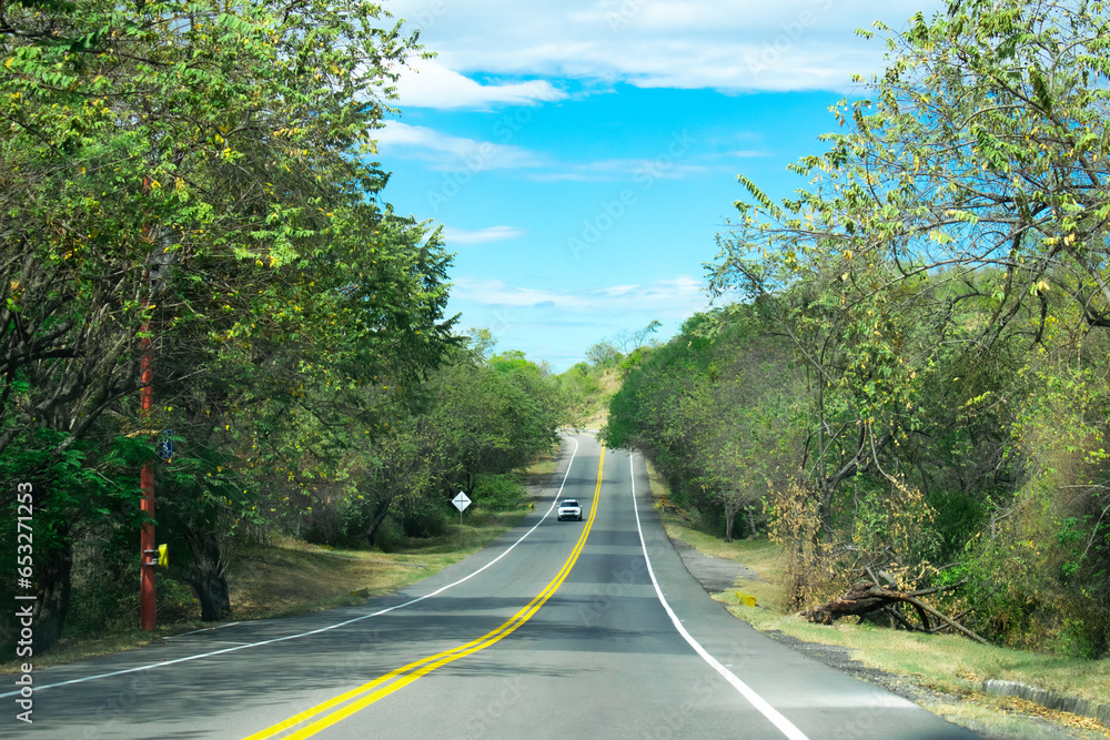 Automóvil el la carretera en la mitad del campo tropical Stock Photo