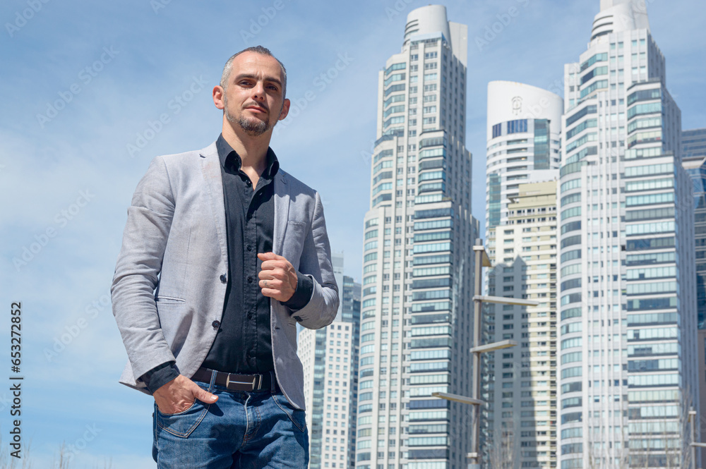 Fototapeta premium caucasian business man standing outdoors looking at camera holding blazer with one hand