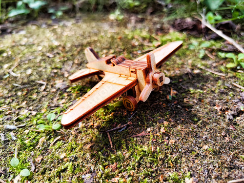 Vintage toy wooden airplane in nature. Private adventure traveling by flight. Aircraft for nature protection, eco friendly, fire extinguishing, rescue of victims. Plane crash, breakdown © keleny