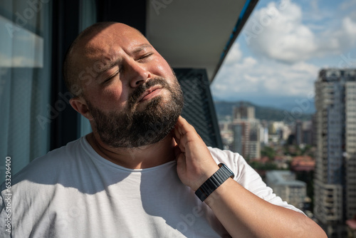Obraz na płótnie Bearded man in hot summer sun on balcony
