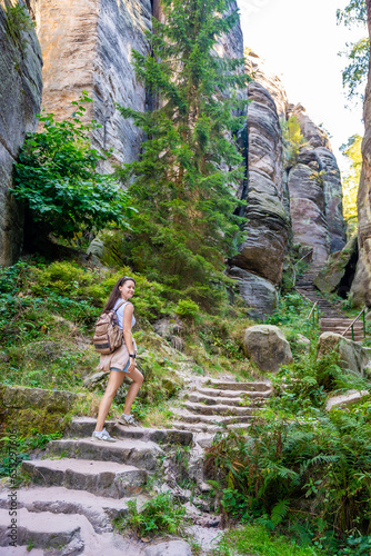 Tourist in Prachovske skaly in sun lights, Cesky raj sandstone cliffs in Bohemian Paradise, Czech Republic photo