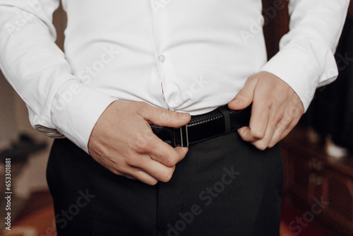 Photo of a man's belt in his hands. Cropped and blurred photo. Men's style. Business. Fashion