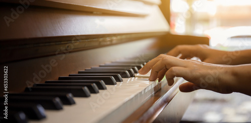 Close up of happy woman's hand playing the piano in the morning.