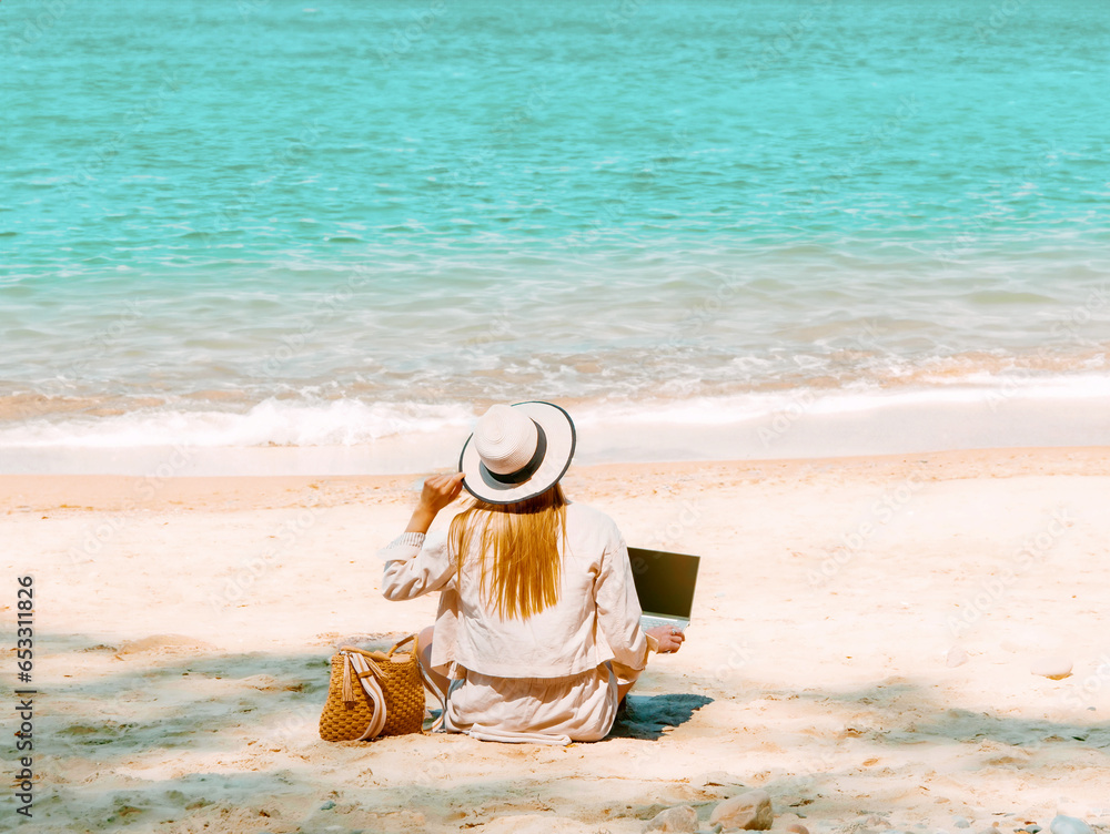 young woman uses laptop computer on the beach. distance work, freelancer and blogger concept. WiFi unlimited