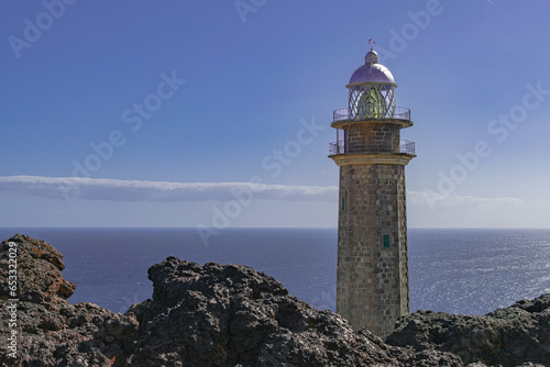 Faro de Orchilla lighthouse, with volcanic rocks and Alantic ocean landscape, with sunset light,  El Pinar, El Hierro, Canary islands, Spain photo